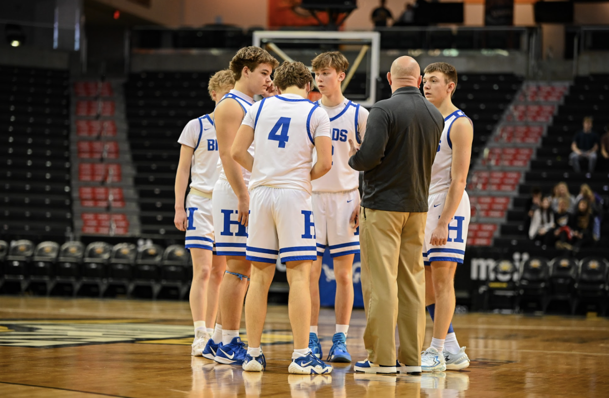 The boys team gets in a huddle before their next period of the game. 